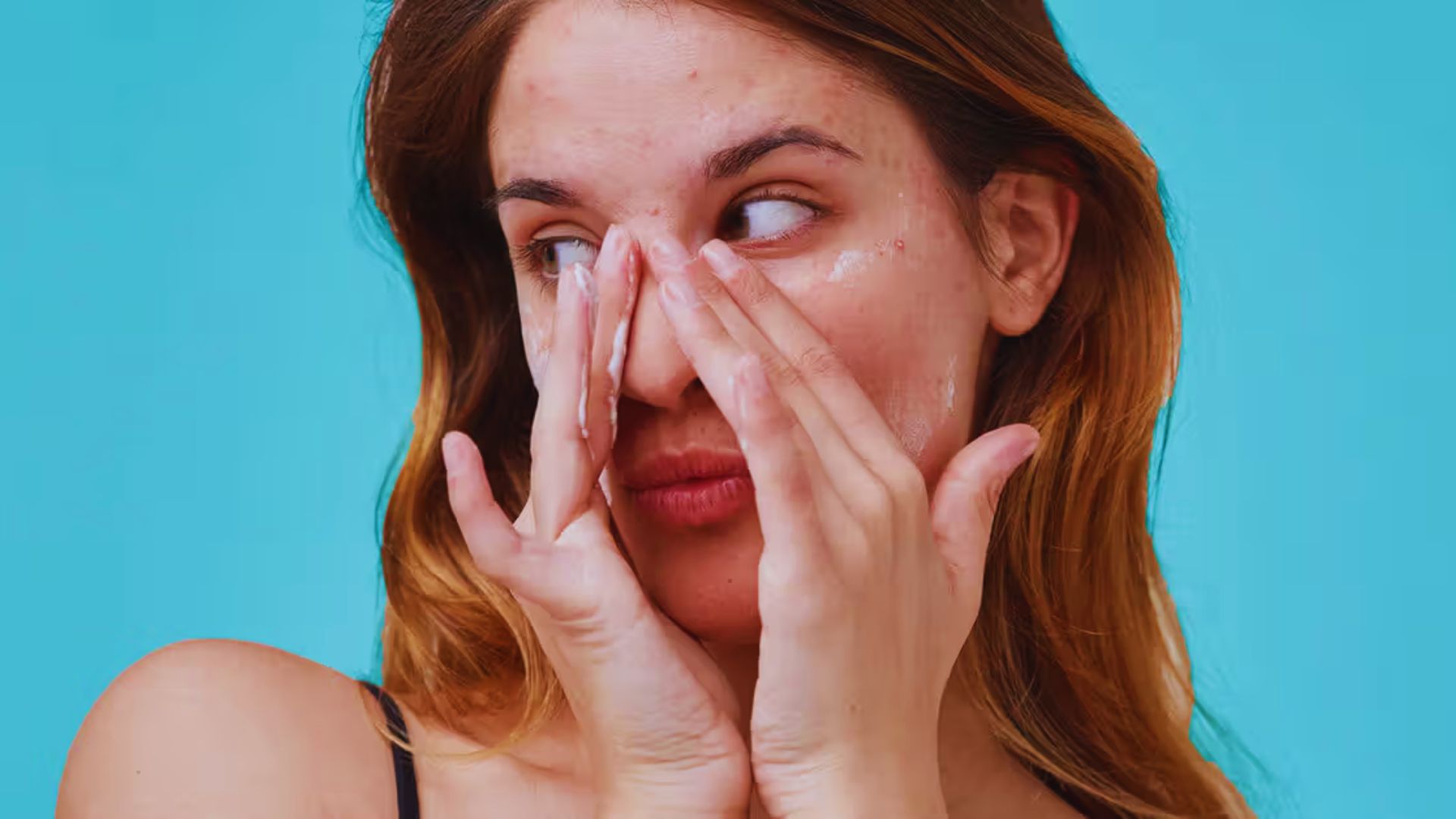 A woman covers her eyes with a white face mask, emphasizing a sense of mystery or concealment.