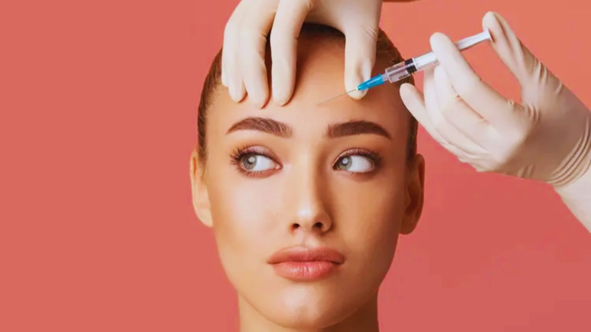 A woman receiving a facial injection in a clinical setting, focused on her face and the medical professional's hands.