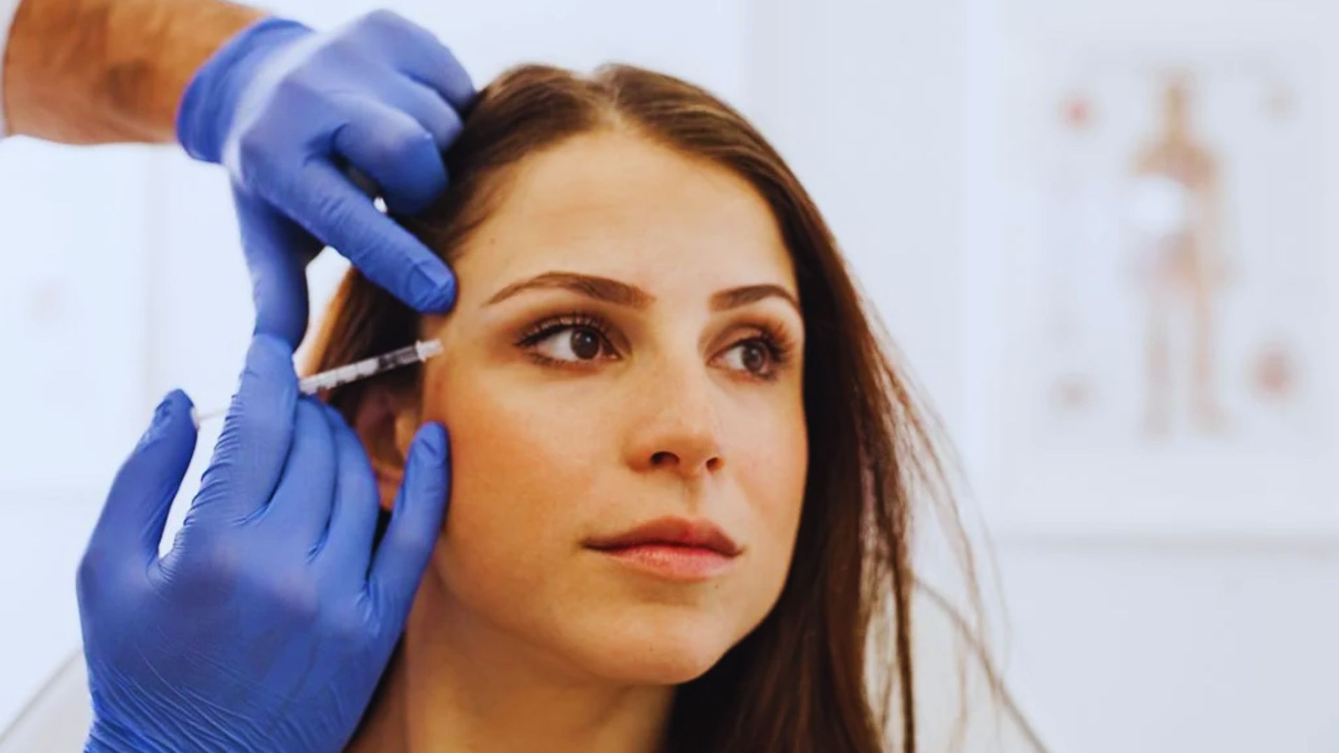 A doctor carefully shaping a woman's eyebrows during a cosmetic procedure.