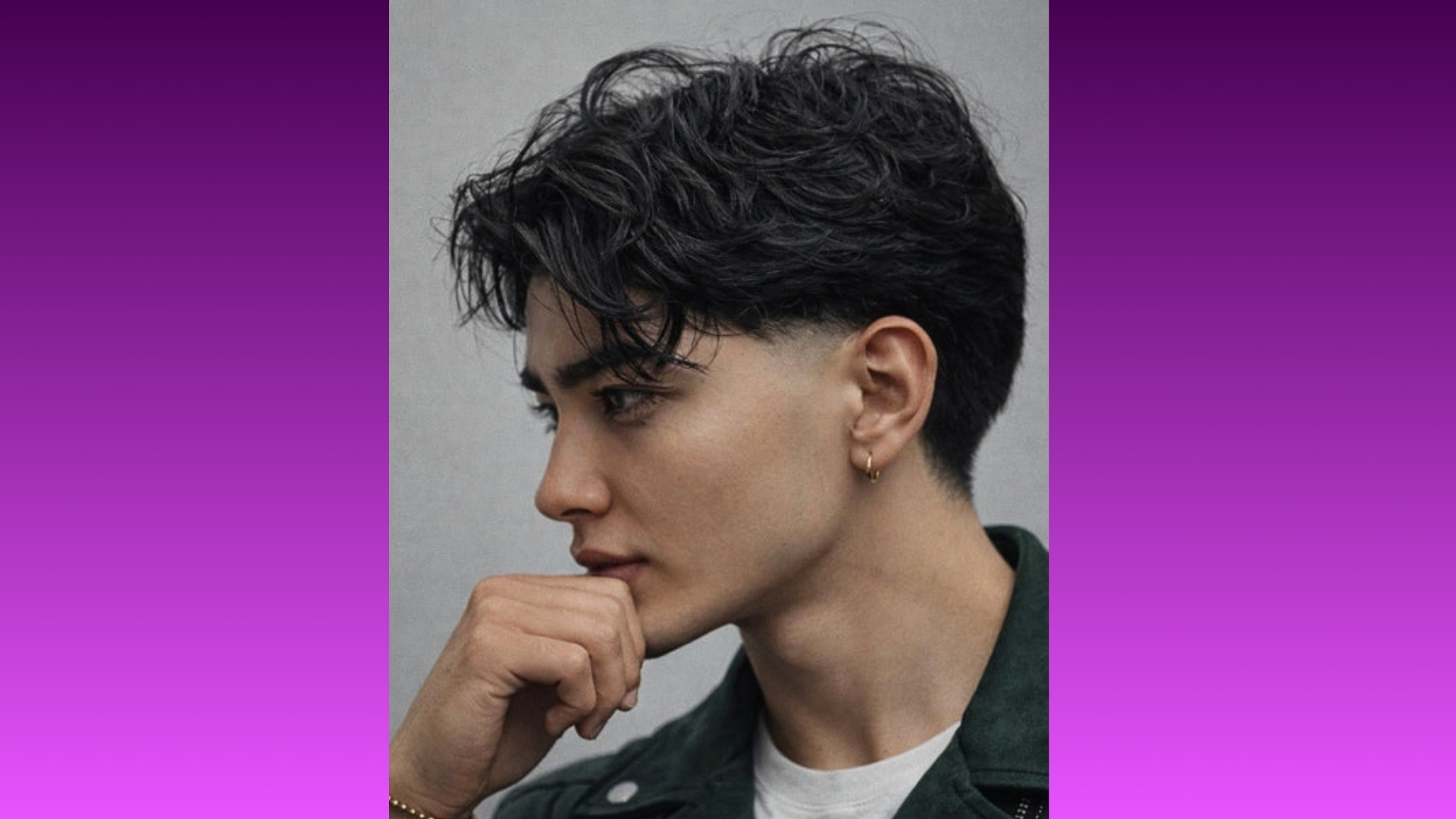 Side profile of a person with short, wavy dark hair, wearing a green jacket. They appear thoughtful, resting their chin on a hand. Purple gradient background.