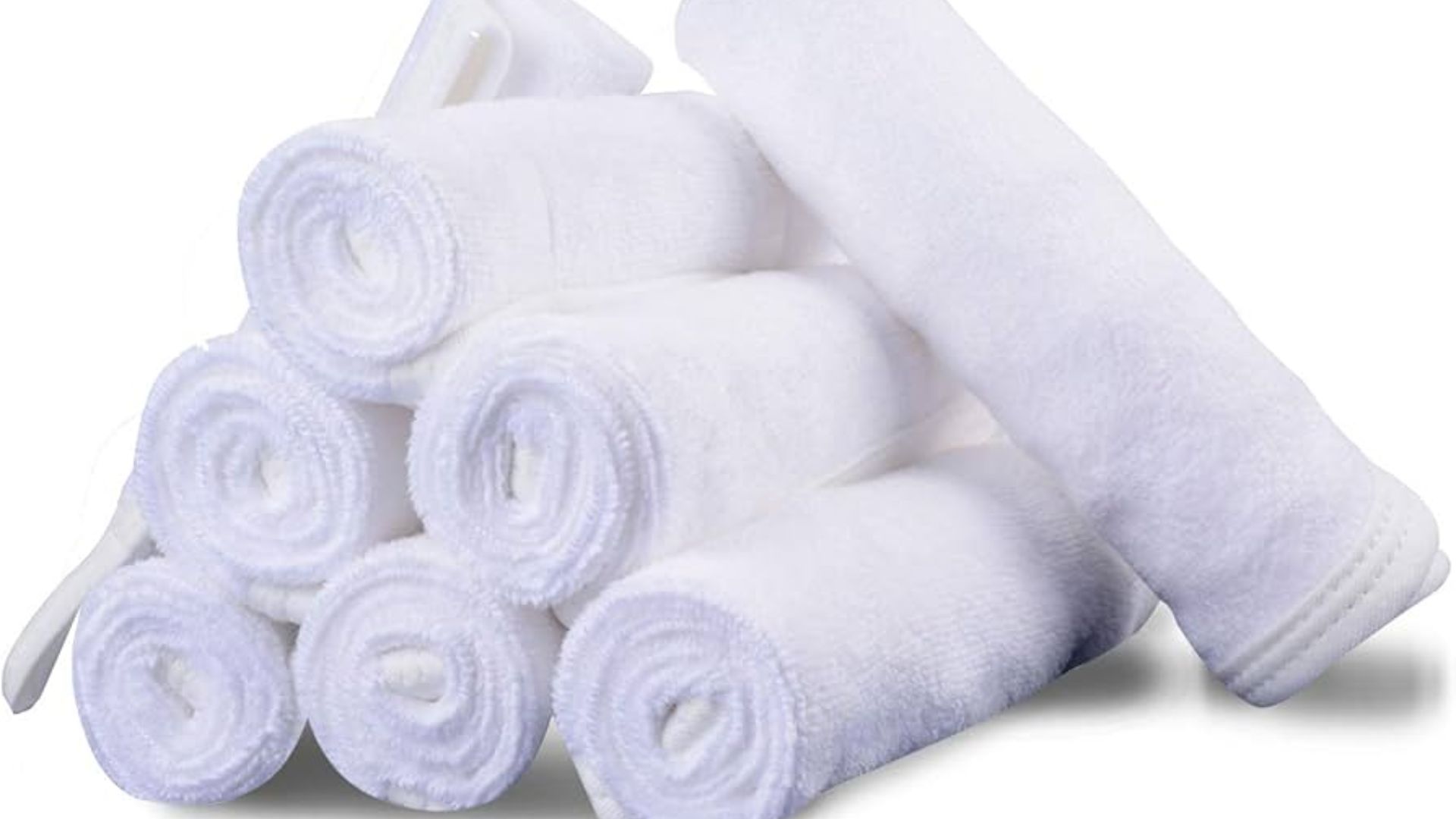 Eight neatly rolled white towels are stacked in a pyramid, conveying a sense of cleanliness and order. The soft texture is clearly visible.