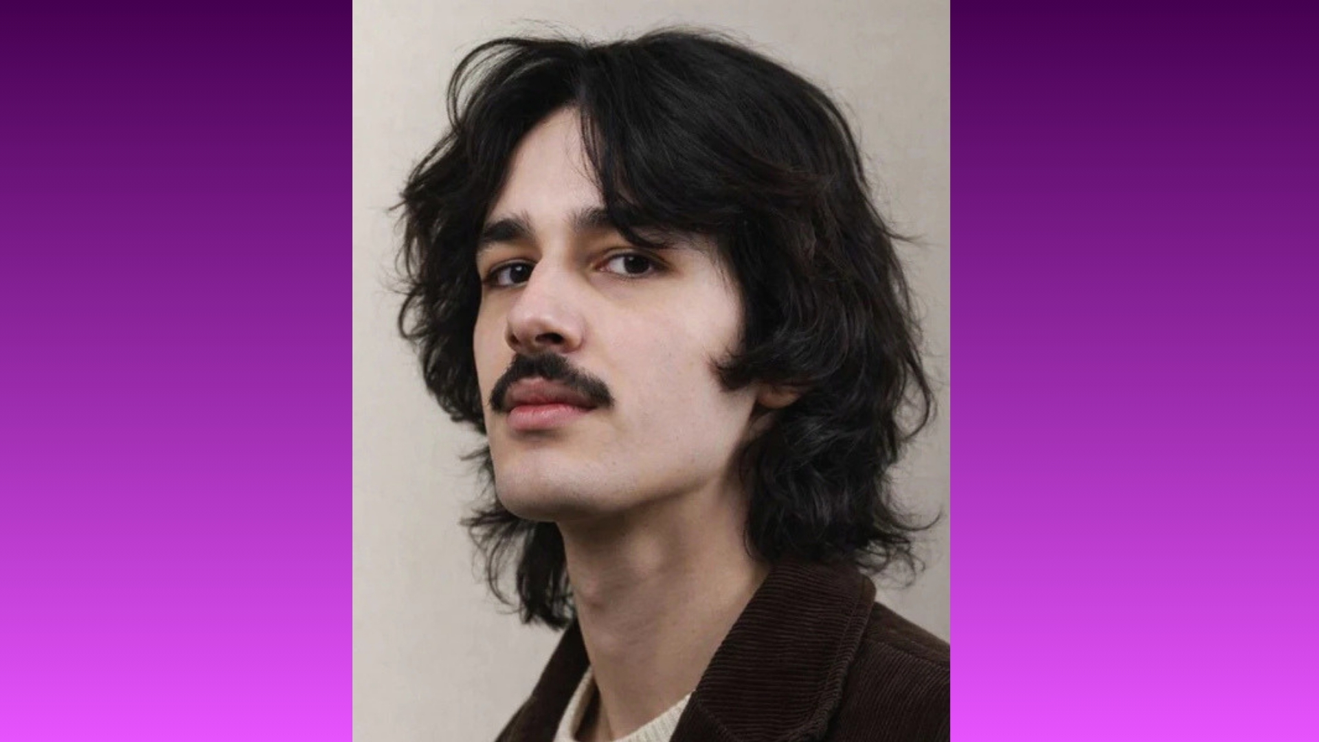 Portrait of a person with long dark hair and a mustache against a gradient purple background. The person is gazing confidently at the camera.