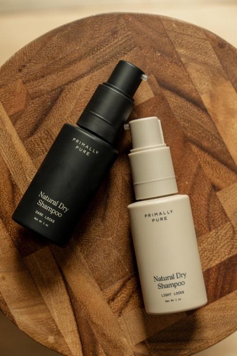 Two natural day serum bottles displayed on a wooden table, highlighting their sleek packaging and organic appeal.