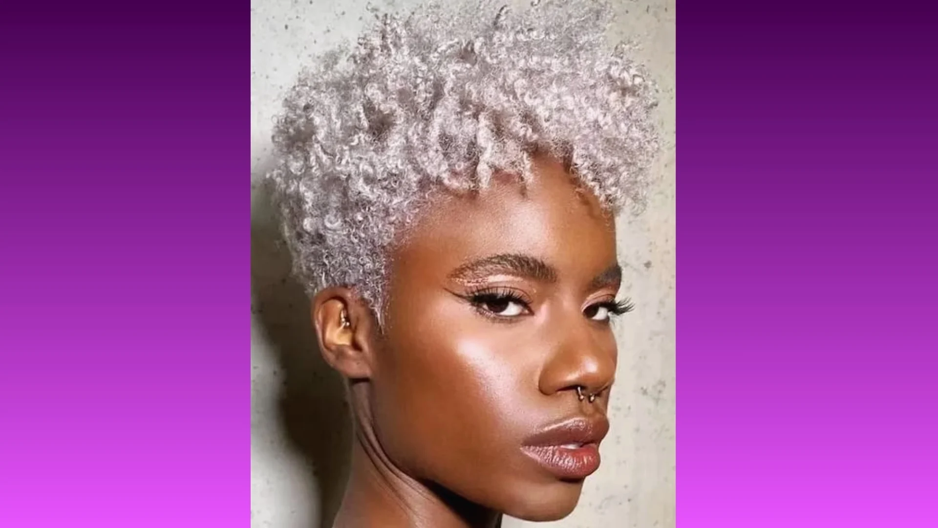 A person with short, curly silver hair and a confident expression. The background is a purple gradient, enhancing the stylish, modern tone.