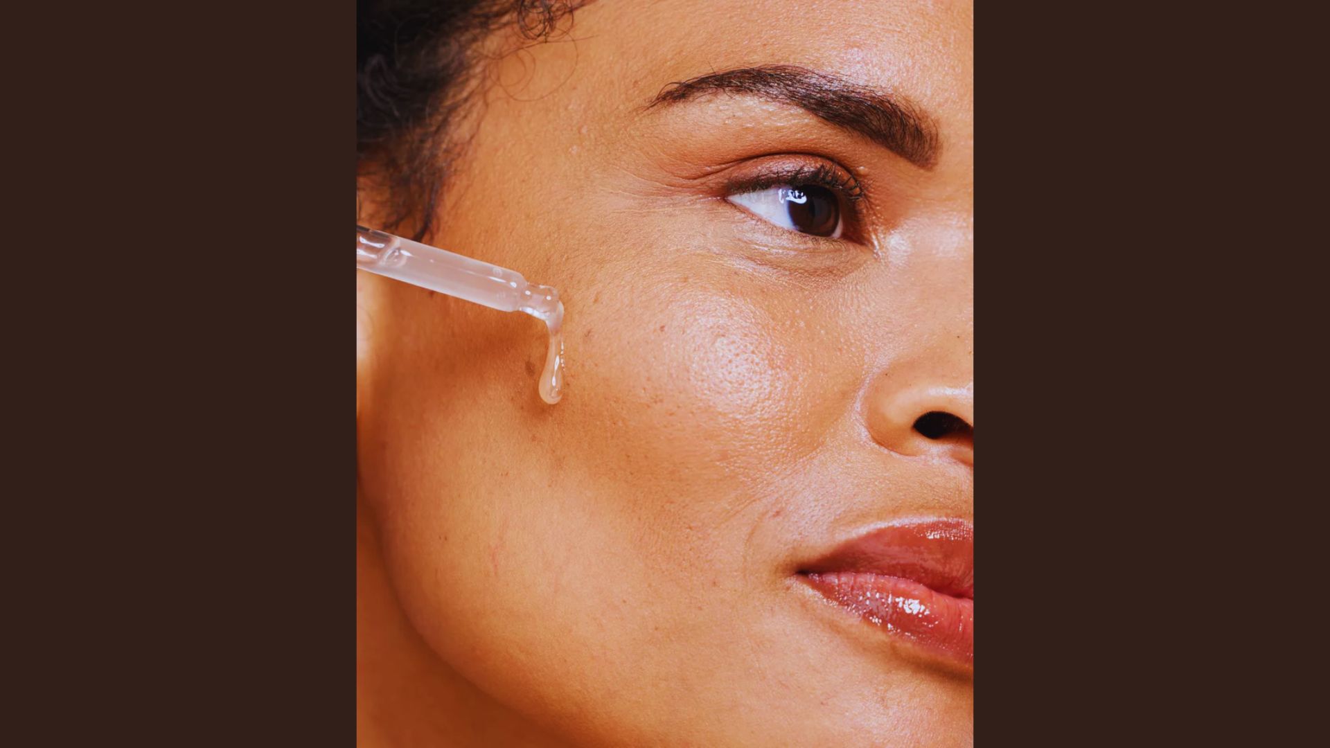 Close-up of a woman's face with a glowing complexion, applying serum with a dropper on her cheek, conveying a sense of freshness and self-care.