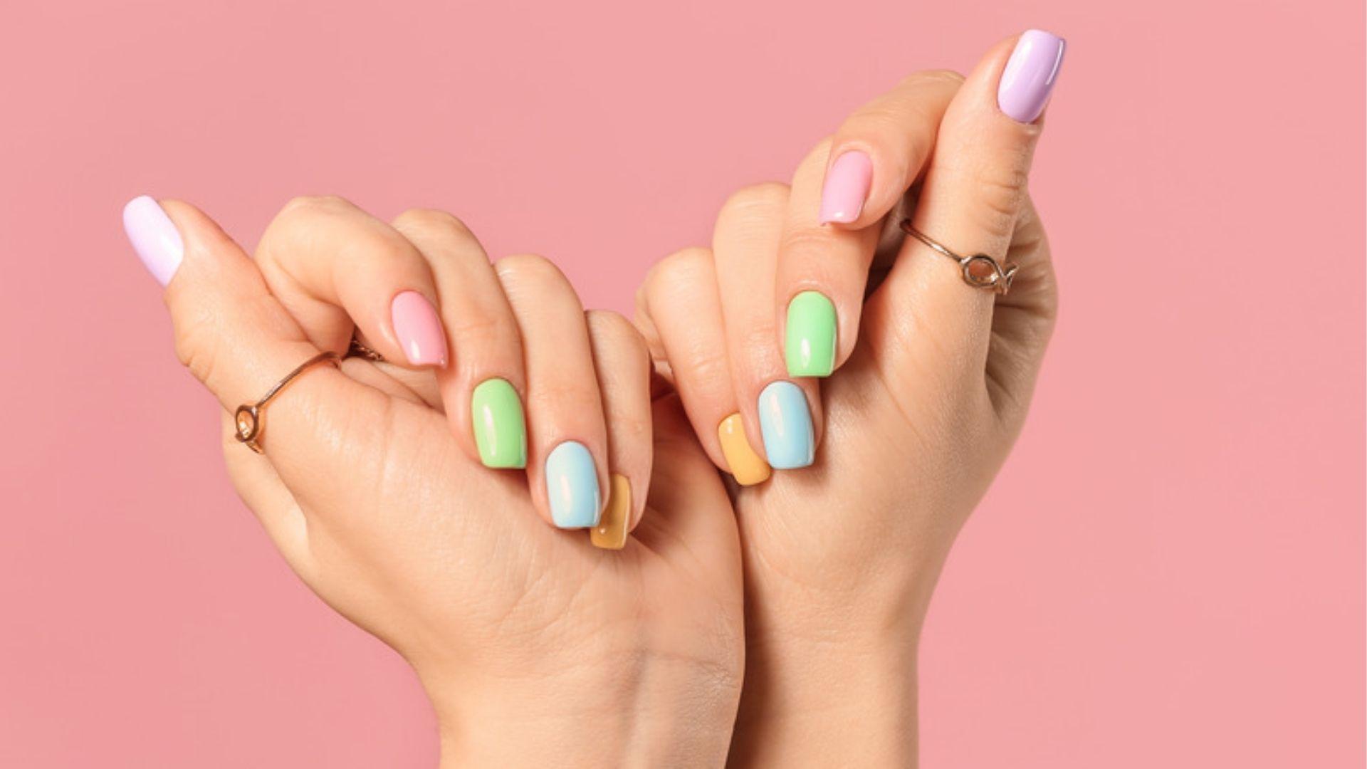 Hands with pastel rainbow gel nails showing glossy finish, quality gel stays chip-free 14+ days.