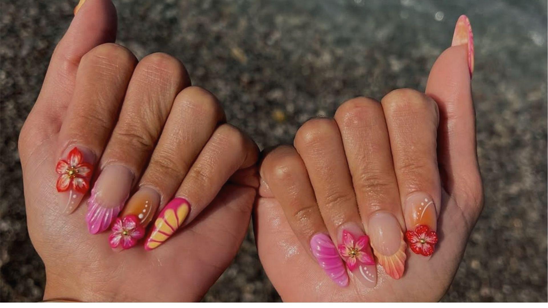 Almond dip nails with nude base, 3D pink flowers, orange ombre, and seashell tips at the beach.