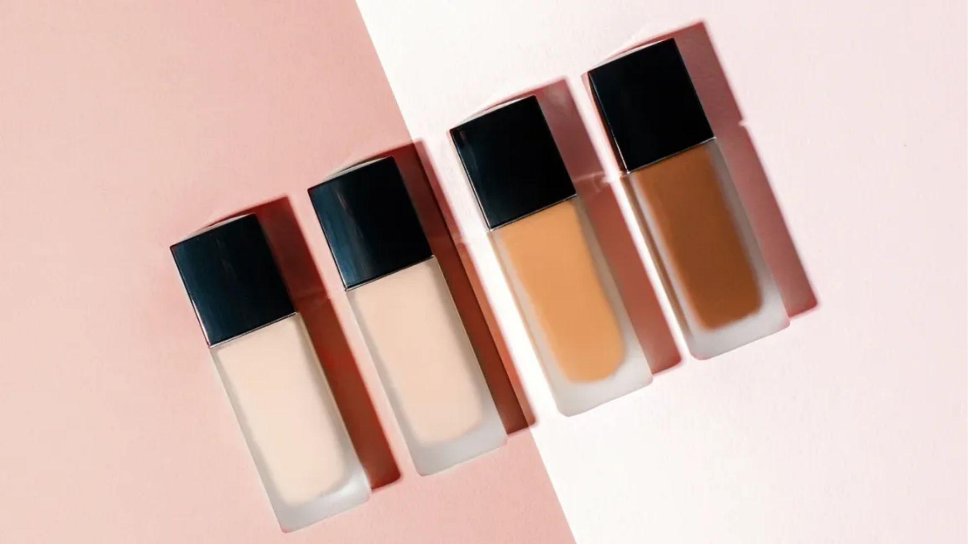 Four BB cream bottles in light to deep shades on a pink background for multiple skin tones.