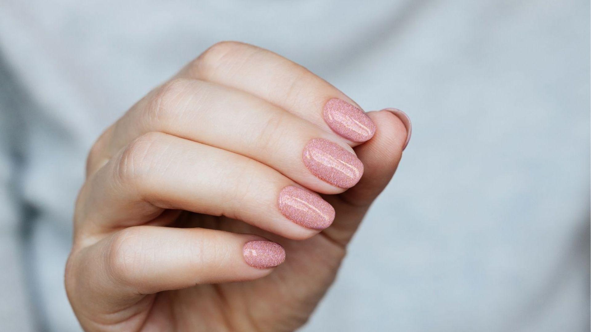 Close-up of shimmery pink gel manicure, well-prepped nails keep gel polish lasting 3 weeks.