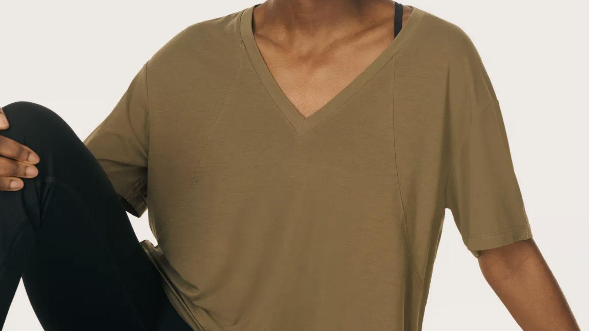 Woman in relaxed olive v-neck tee and black leggings, soft loose top great for fresh spray tan