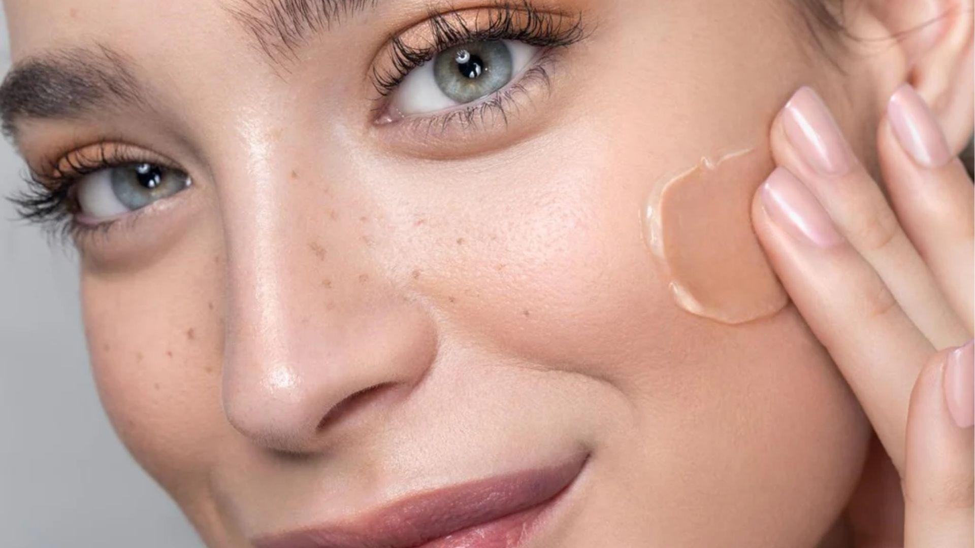 Woman gently blending BB cream on cheek with fingers, showing sheer, skin-like finish.
