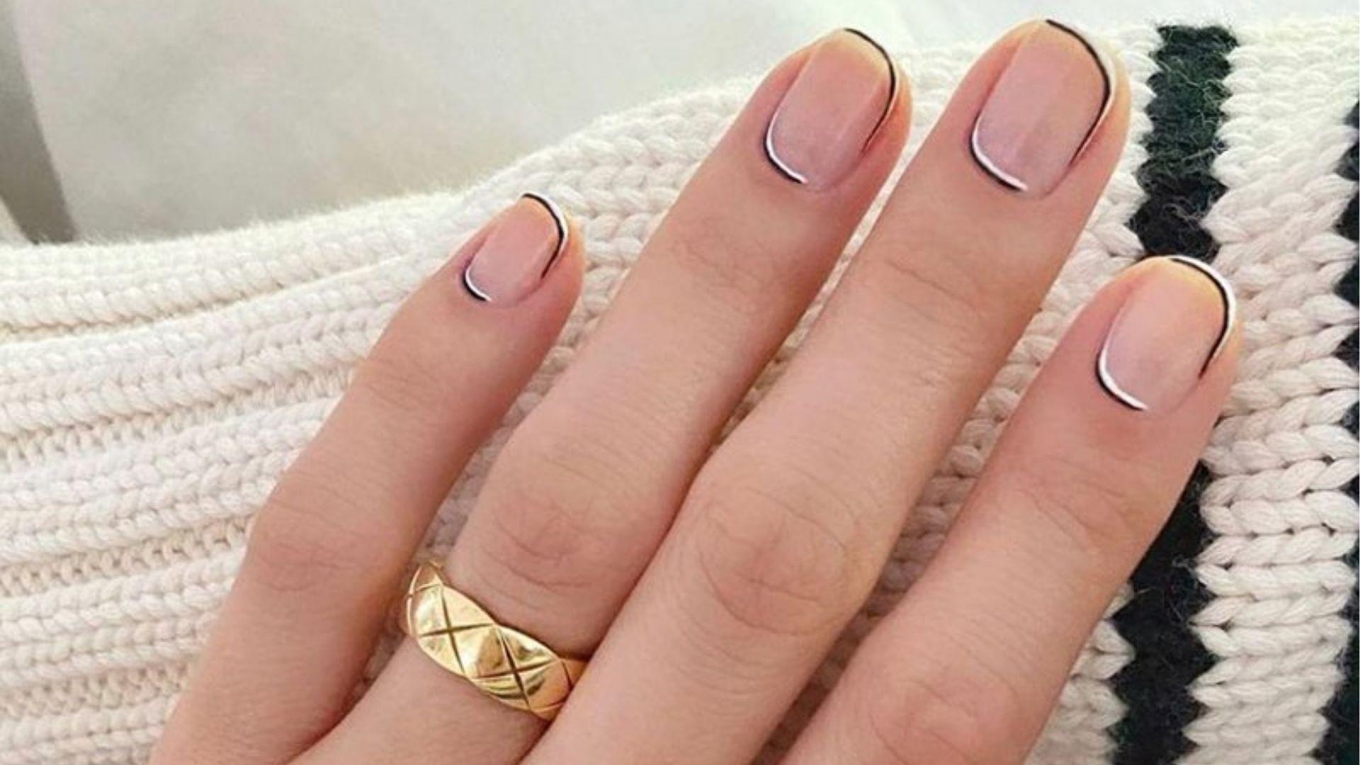 Short square dip nails with sheer nude base and ultra-thin black and white double micro French tips.