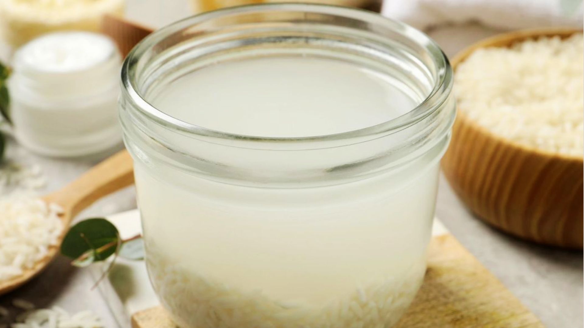 A clear jar filled with rice water prepared for hair care use