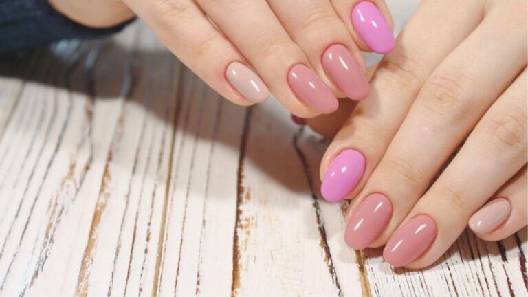 Medium-length oval gel nails in gradient shades of nude, dusty rose, and bright pink with a glossy finish.