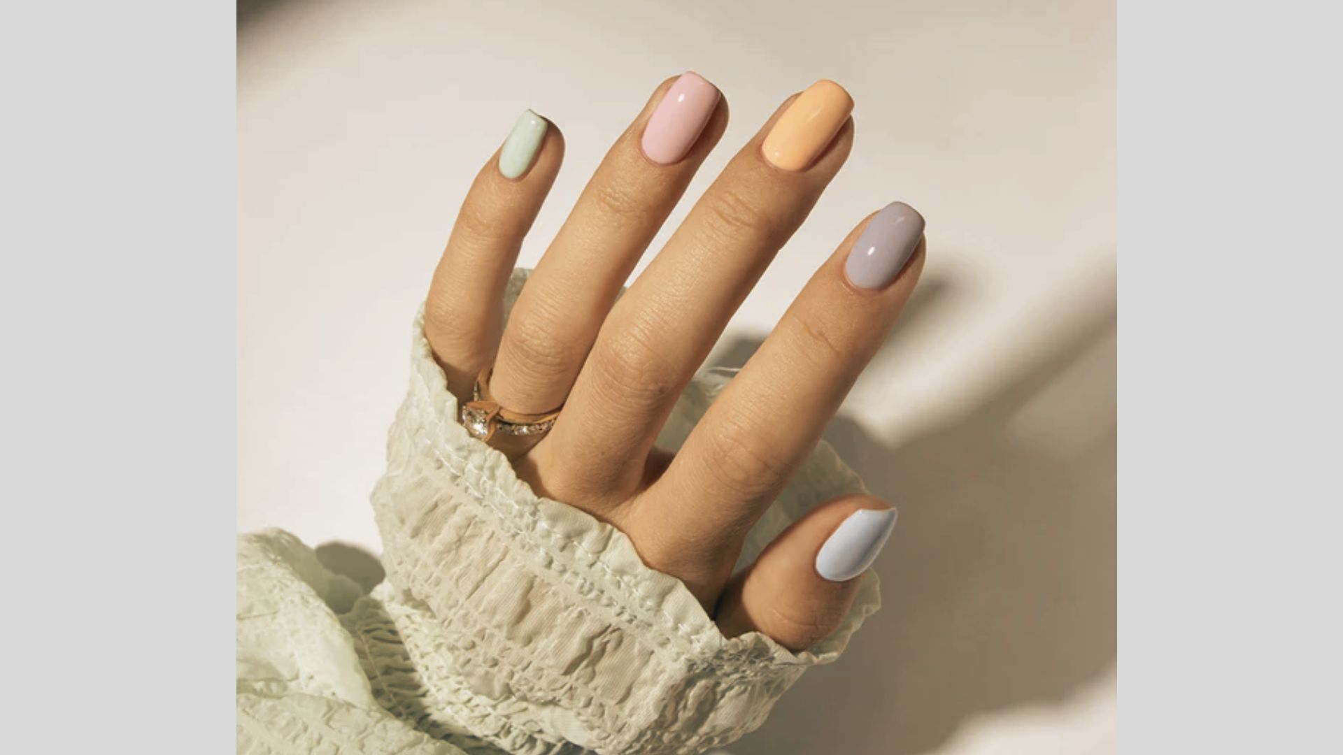 Short square gel nails painted in alternating pastel shades of mint green, blush pink, peach, lavender, and baby blue
