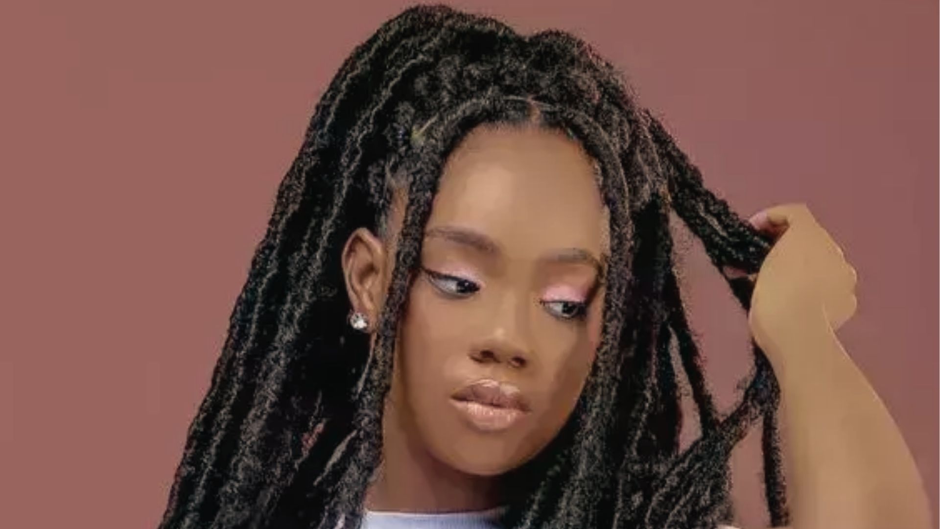 Half up half down faux locs style with face framing pieces and diamond stud on mauve backdrop