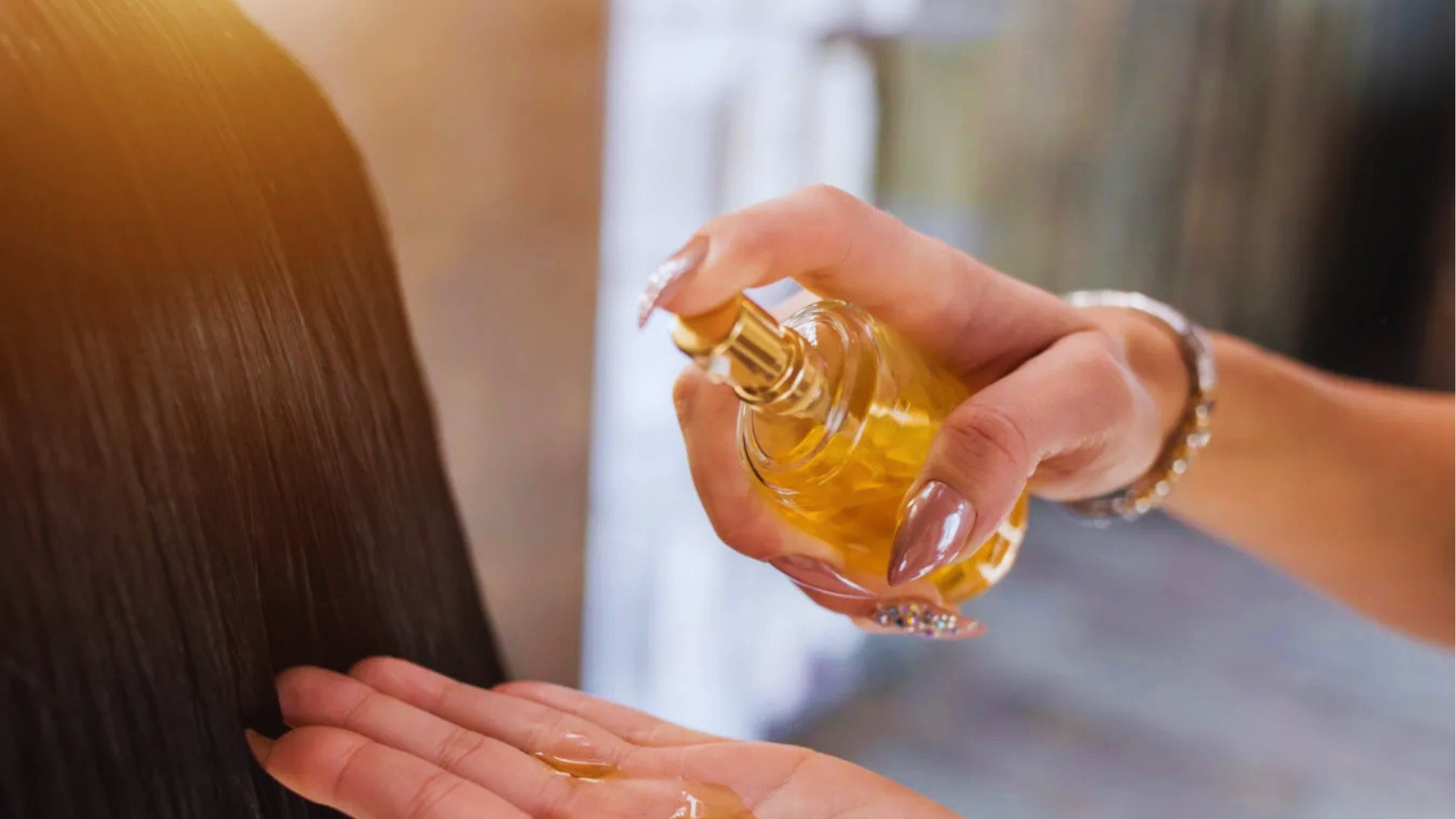 Close-up of woman with manicured nails pumping vitamin E oil from glass bottle into palm for hair treatment.