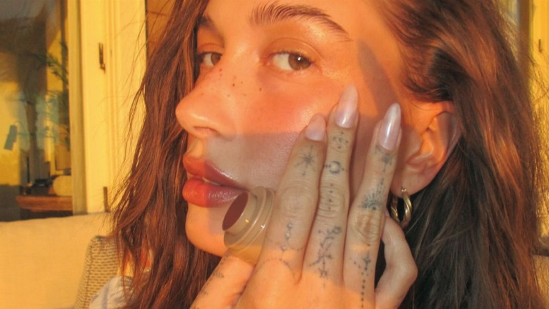 Hailey Bieber shows off pearly glazed donut nails in golden hour selfie with finger tattoos