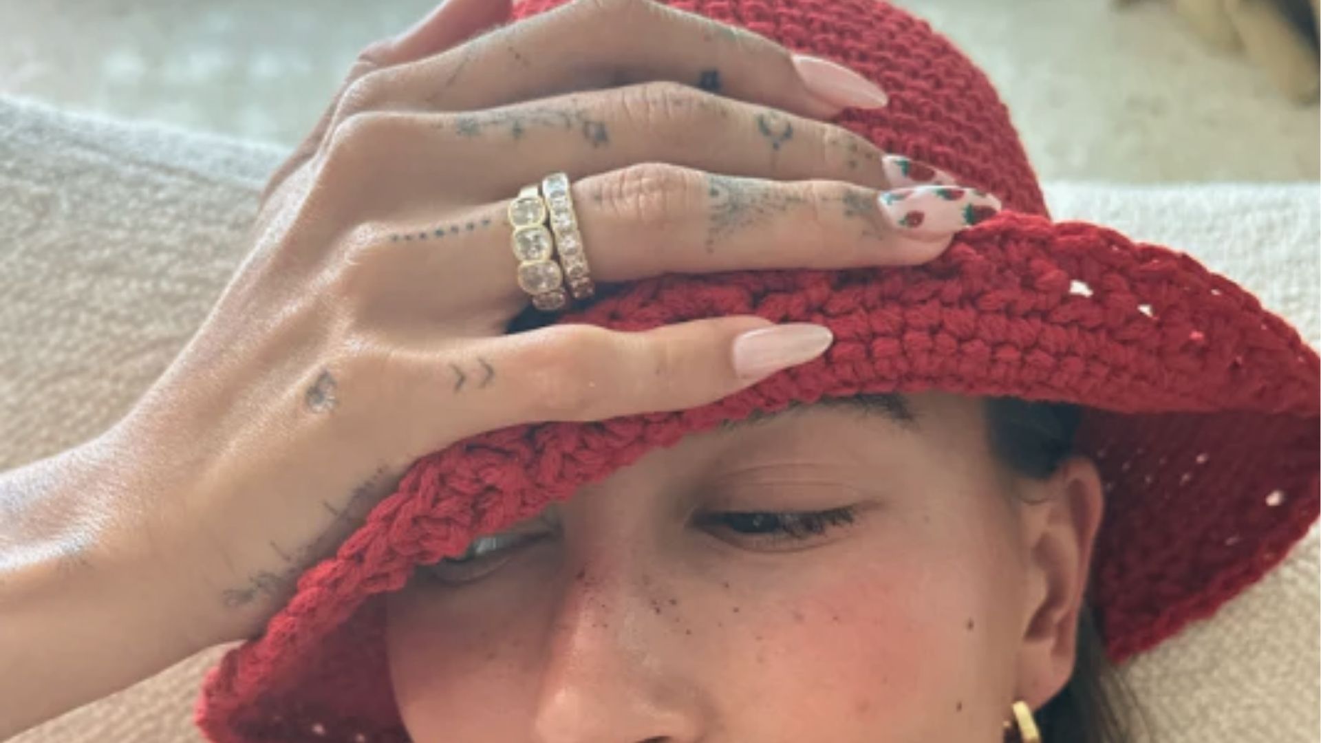 Hailey Bieber wears red crochet hat with glossy glazed donut nails and strawberry nail art