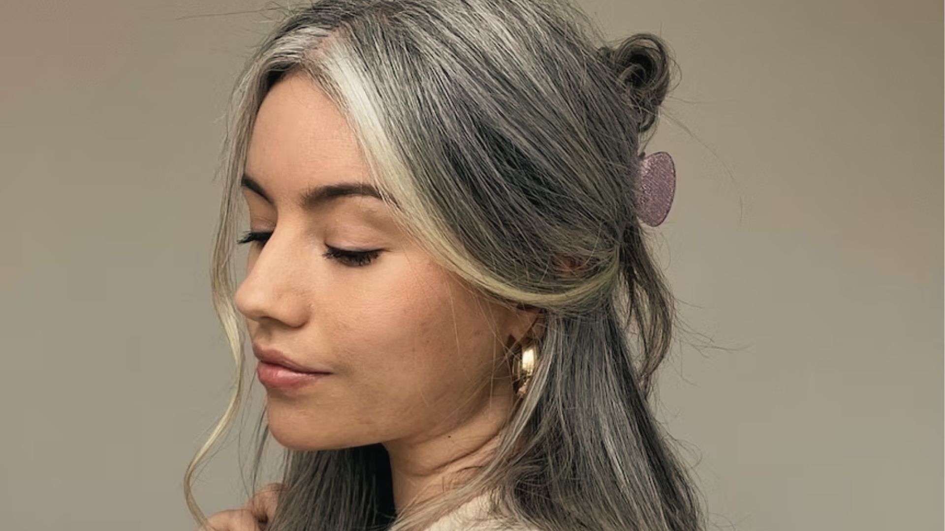 Woman with gray and blonde hair in half updo
