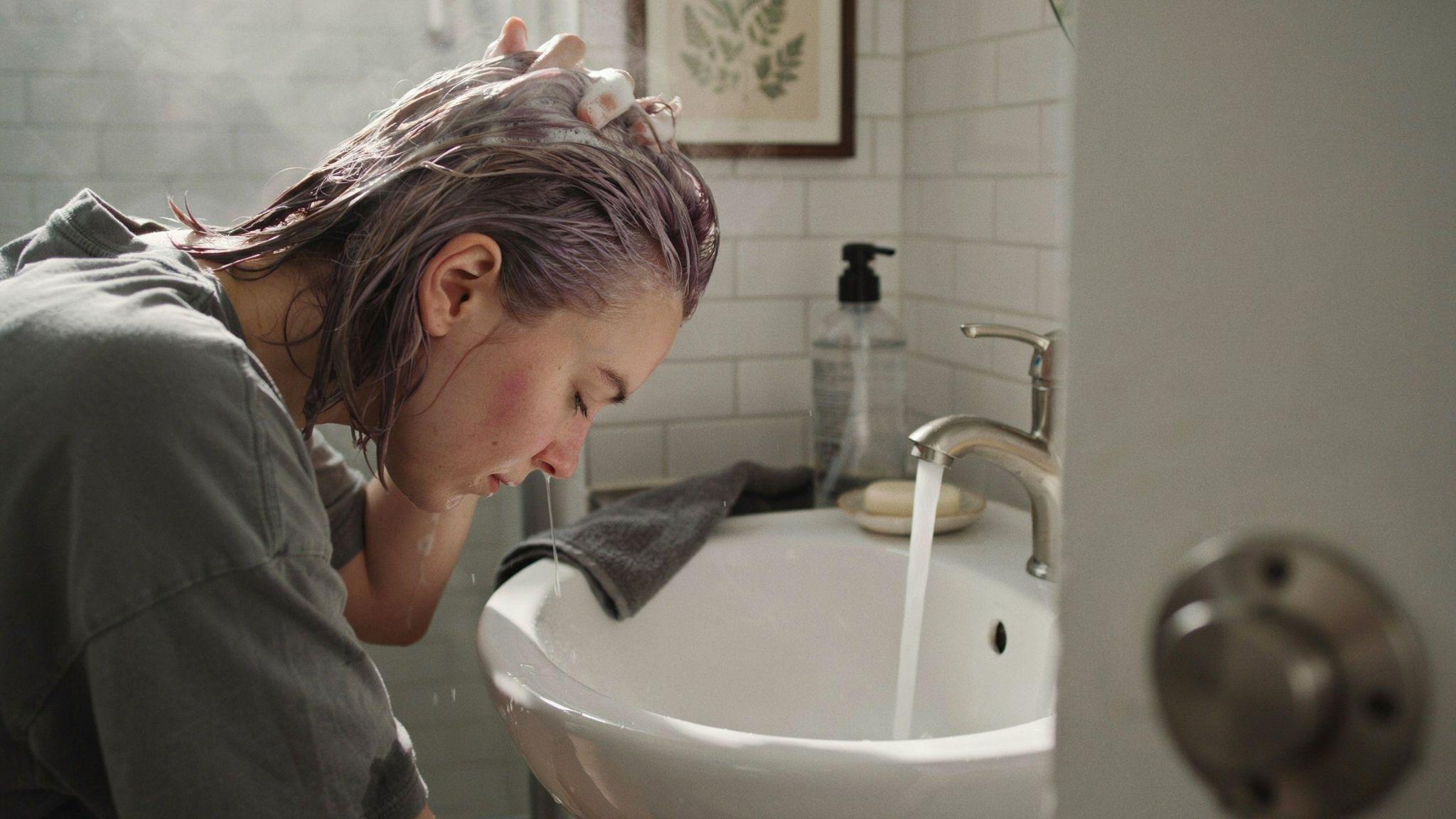 Person washing hair with clarifying shampoo to fade semi-permanent hair dye.