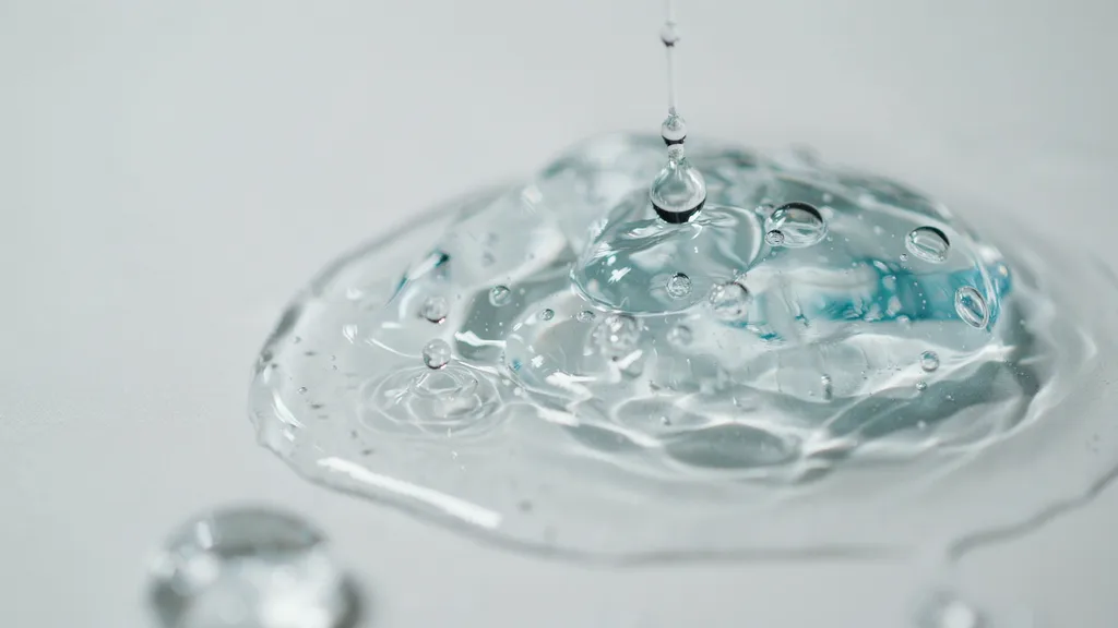 close up of hydrating serum texture with water droplets showing hyaluronic acid moisture retention and smooth glossy skin hydration effect clearly.