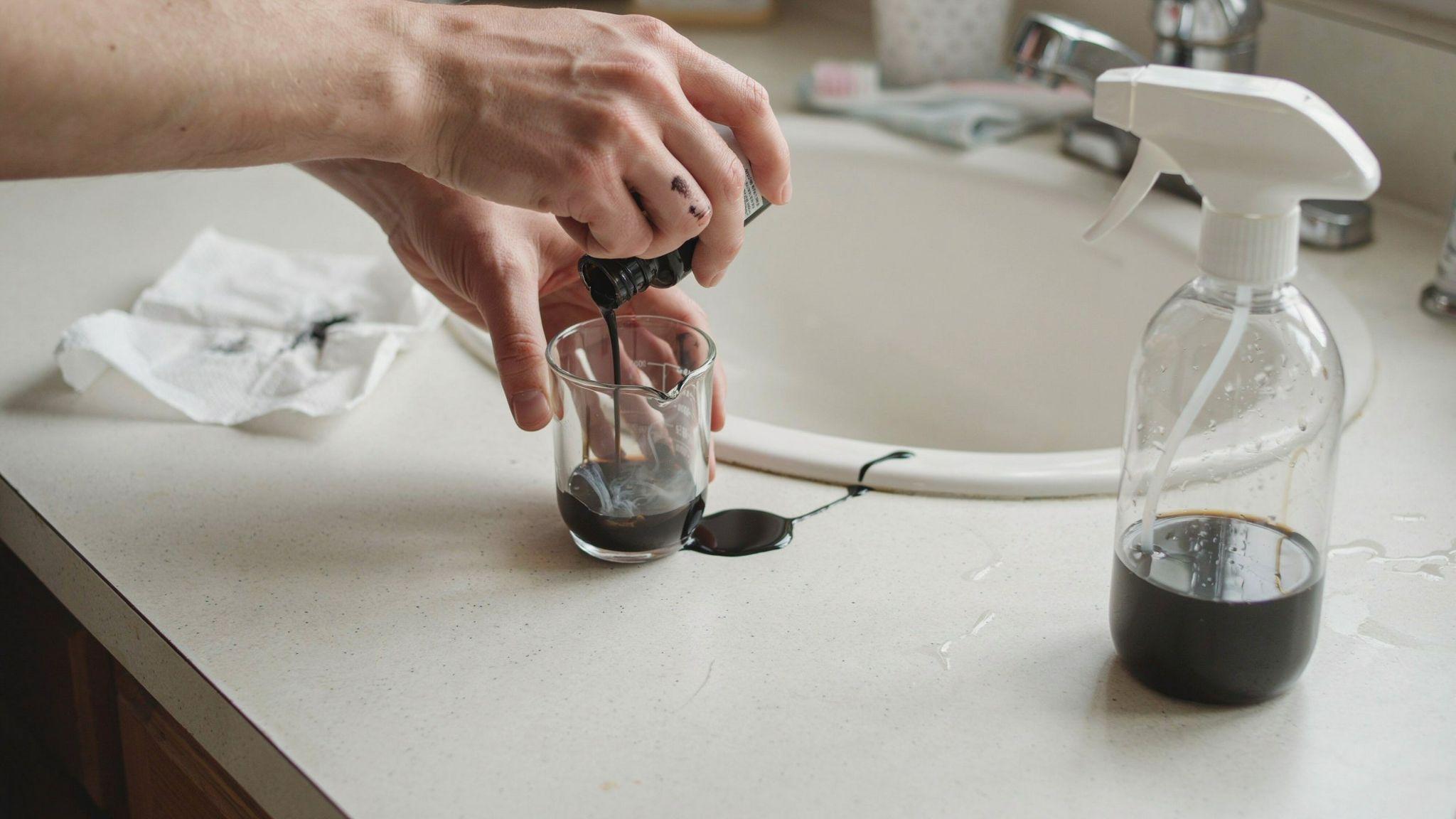 Ink and alcohol being mixed into a spray bottle for dyeing synthetic hair.