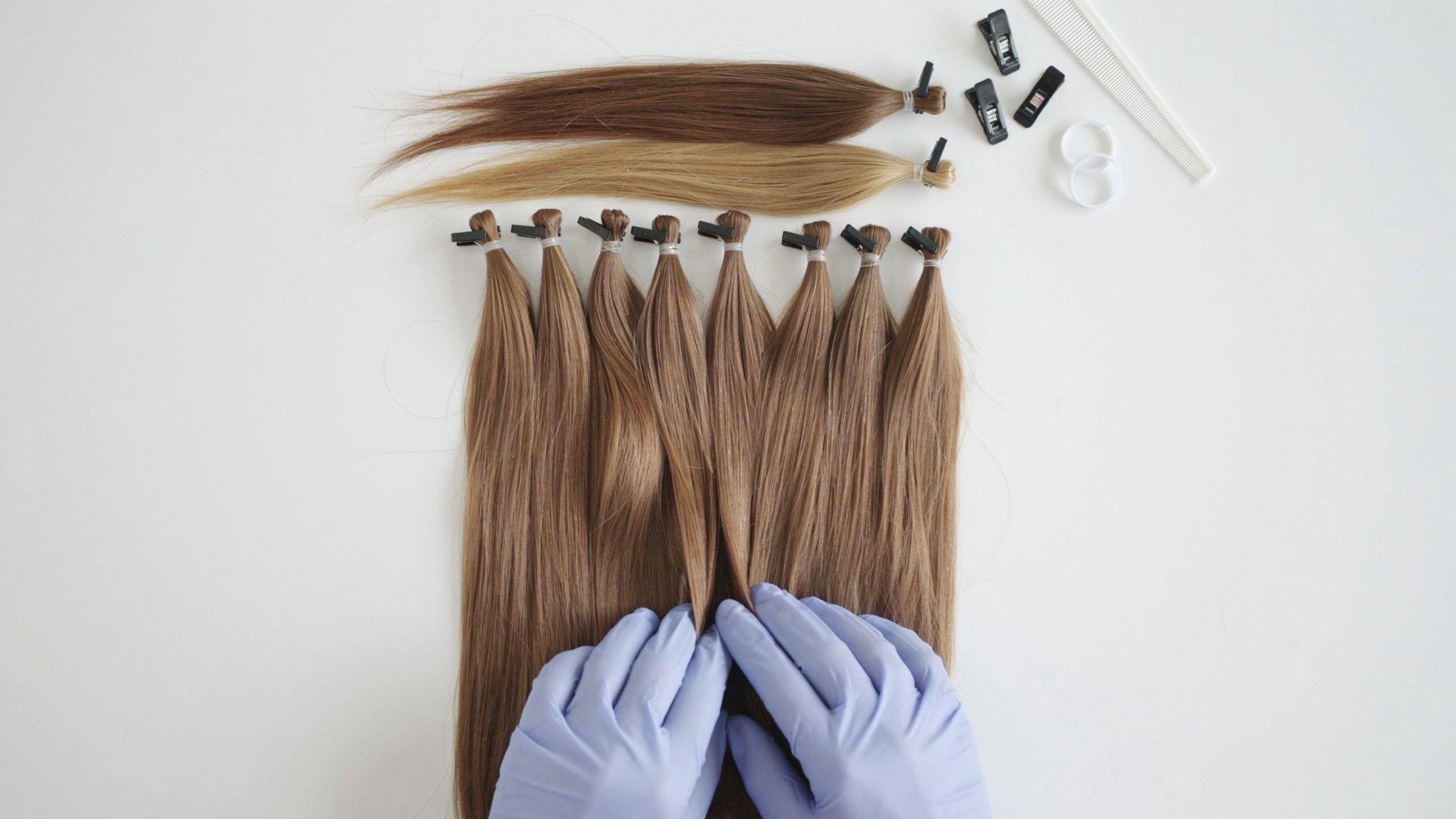 Synthetic hair being sectioned with clips before dye application.