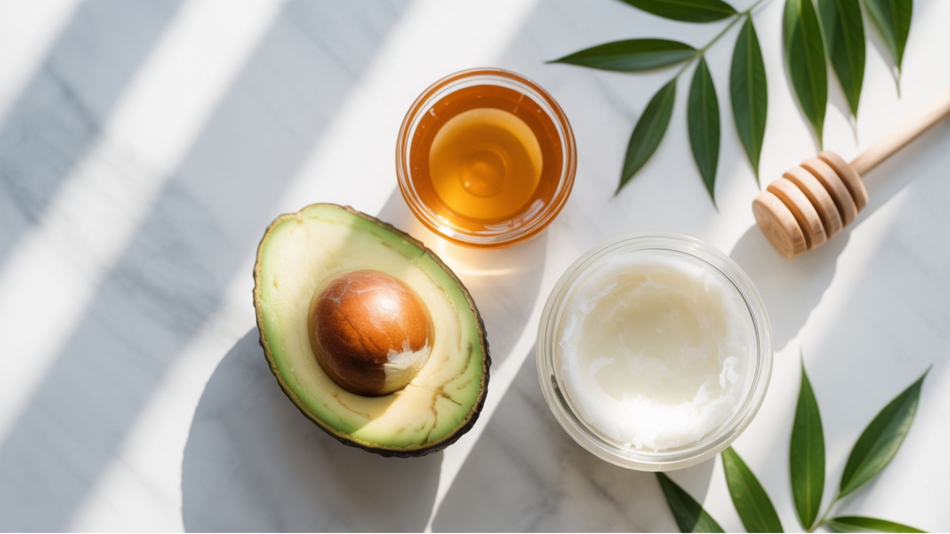 A white marble background features avocado oil, honey, and an avocado, showcasing ingredients for frown line remedies.
