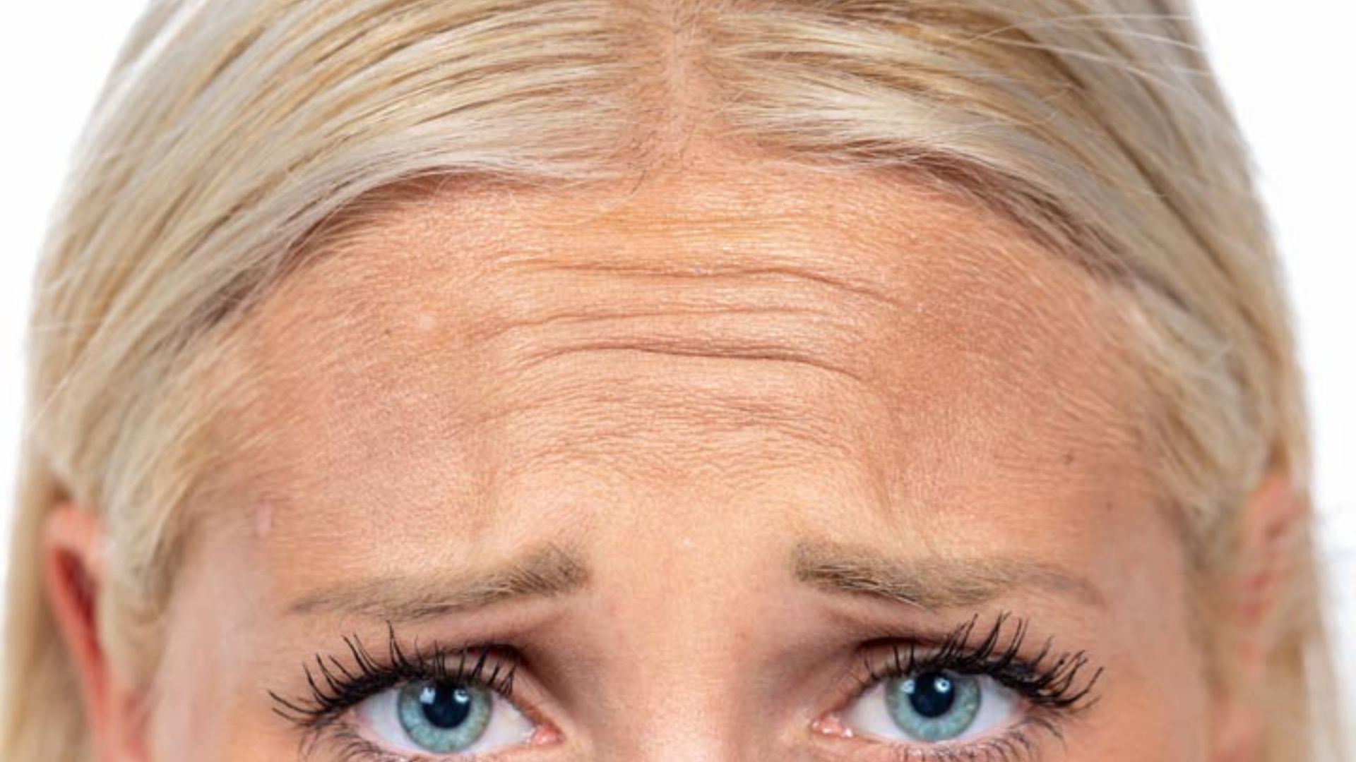 A woman with a frown on her face, highlighting her frown lines and expressing a sense of displeasure or concern.