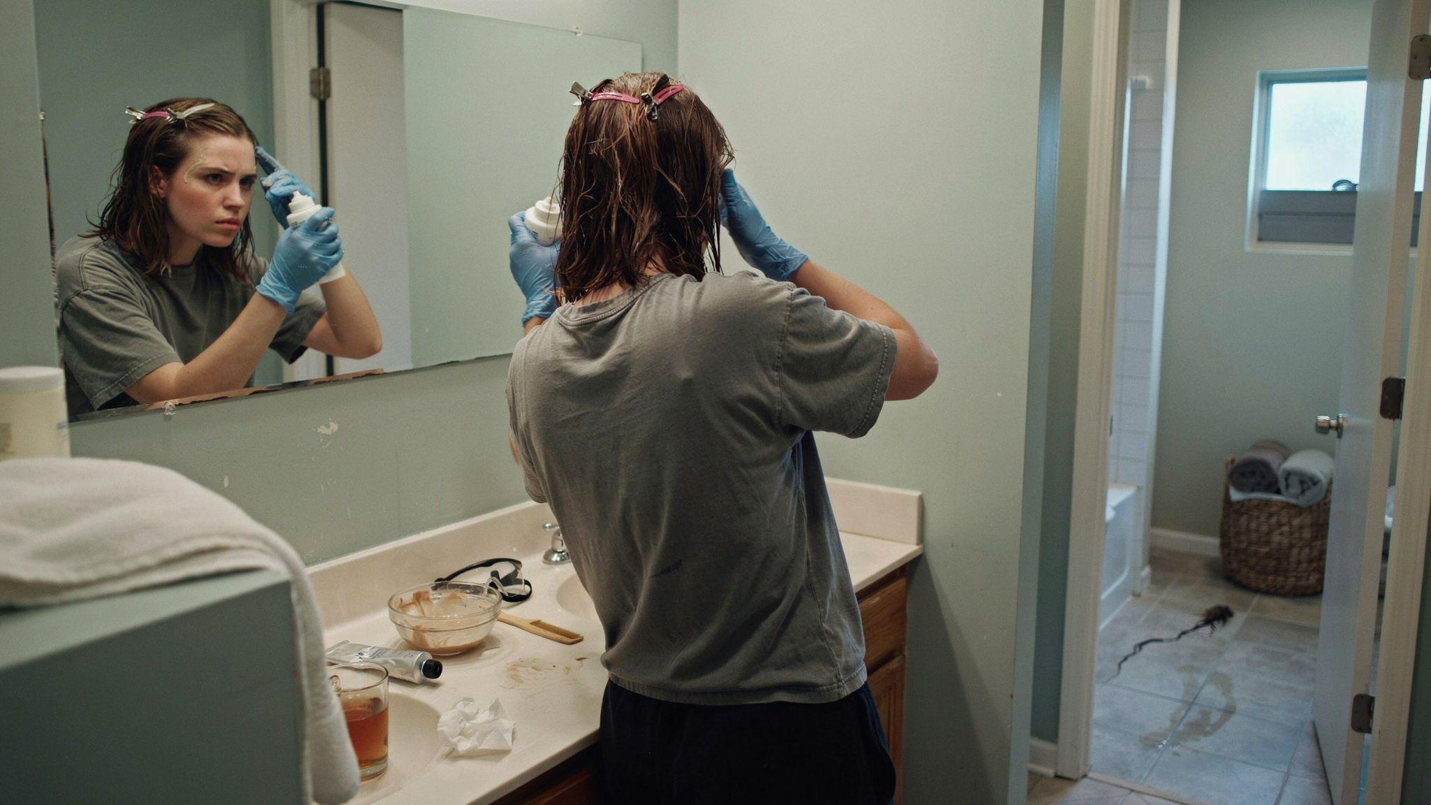 Person using color remover product on semi-permanent dyed hair.