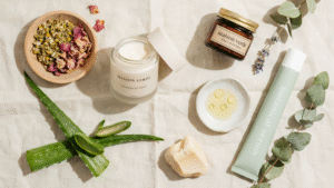 Natural face moisturizers in jars with aloe vera shea butter and plant ingredients arranged on a clean minimal background.