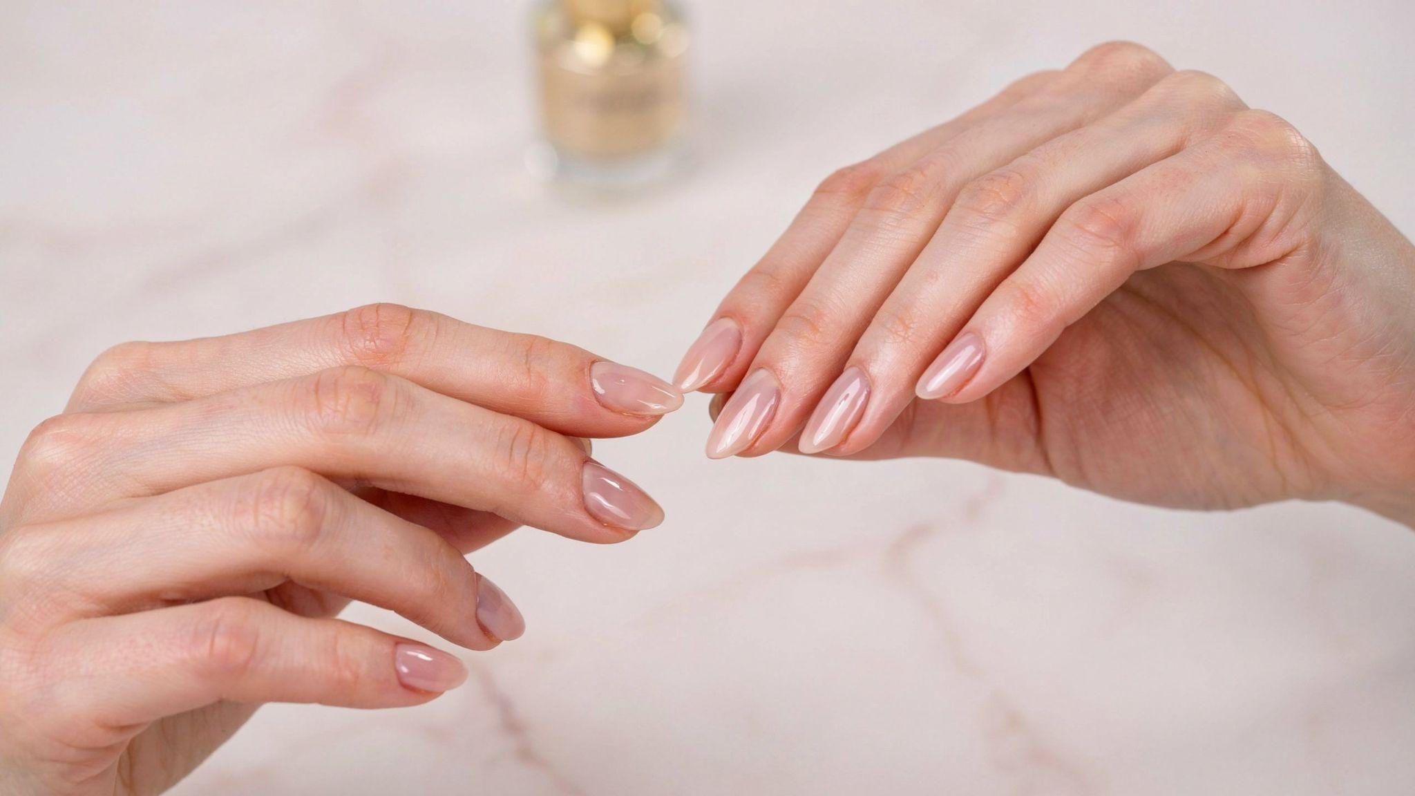 Manicured nails gently tapping together to check fully dried and cured polish