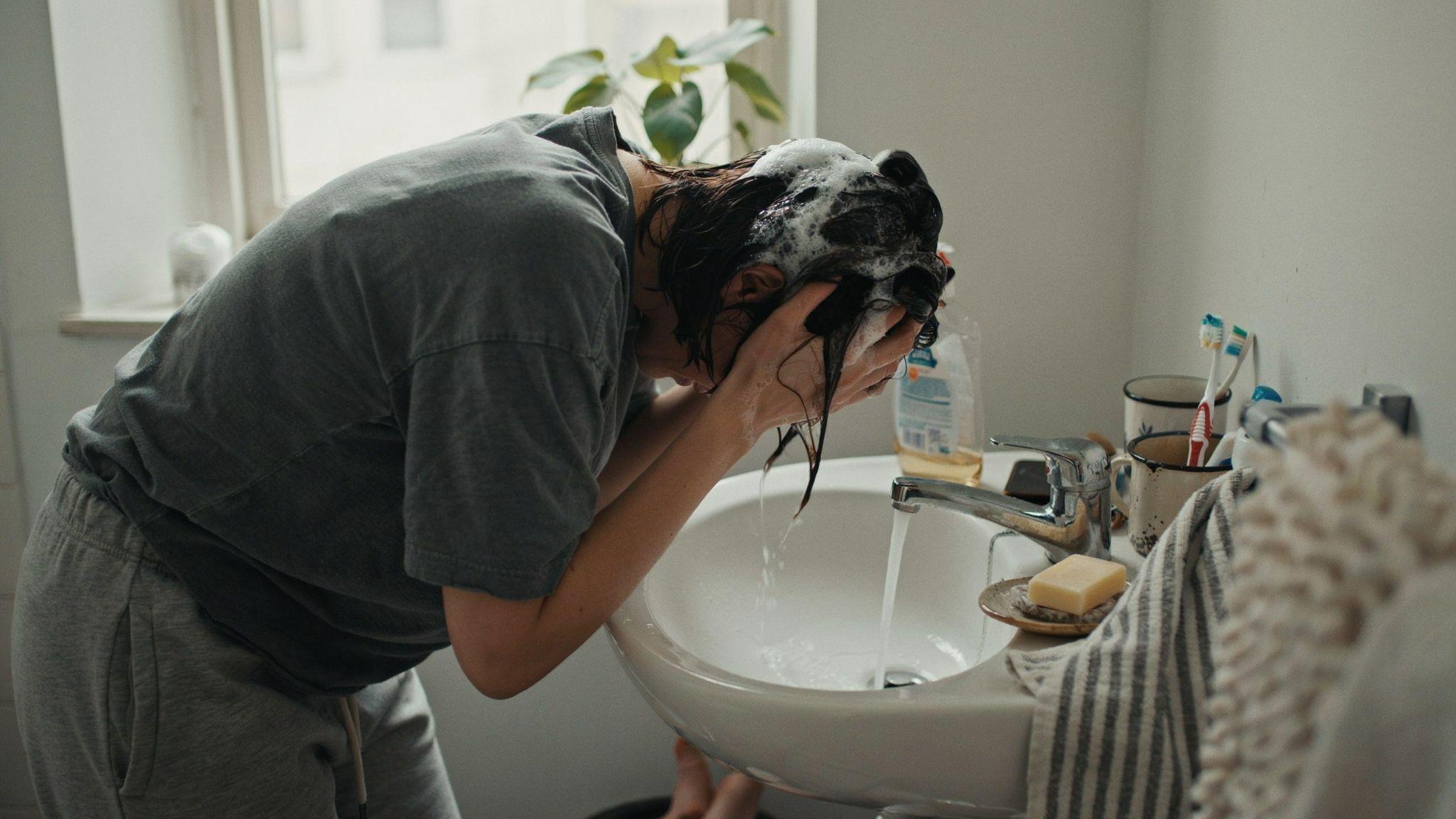 Person using dish soap to strip semi-permanent hair dye.