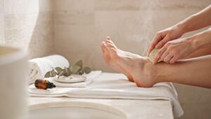 Smooth heels receiving pumice stone exfoliation in bright spa setting with healthy skin texture