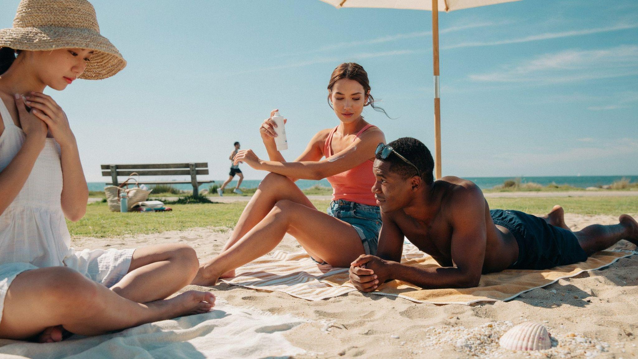 People tanning safely under UV 4 sunlight while using sunscreen and shade protection.