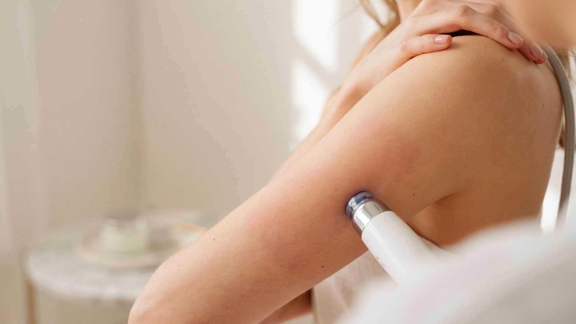 A person getting laser hair removal done on arms, emphasizing smooth skin and self care.