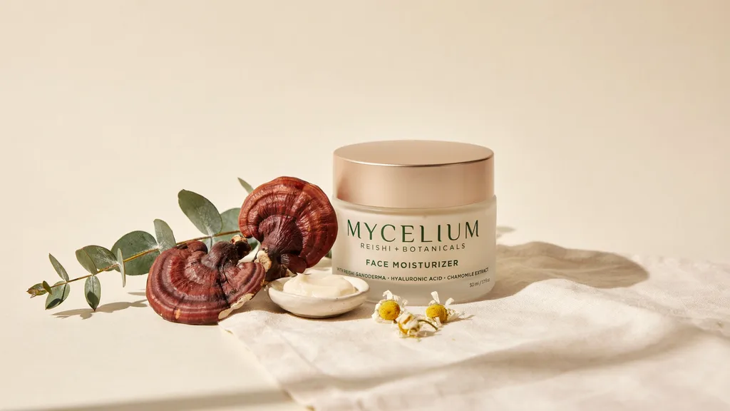 Mushroom face moisturizer with reishi mushrooms and botanical elements arranged on minimal clean background.