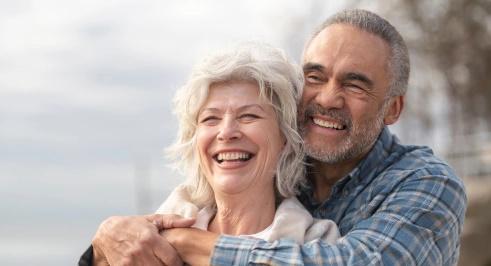 An older couple smiling and embracing each other, radiating warmth and affection.