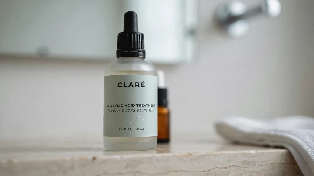 Salicylic acid serum being applied to a small acne spot on the skin.