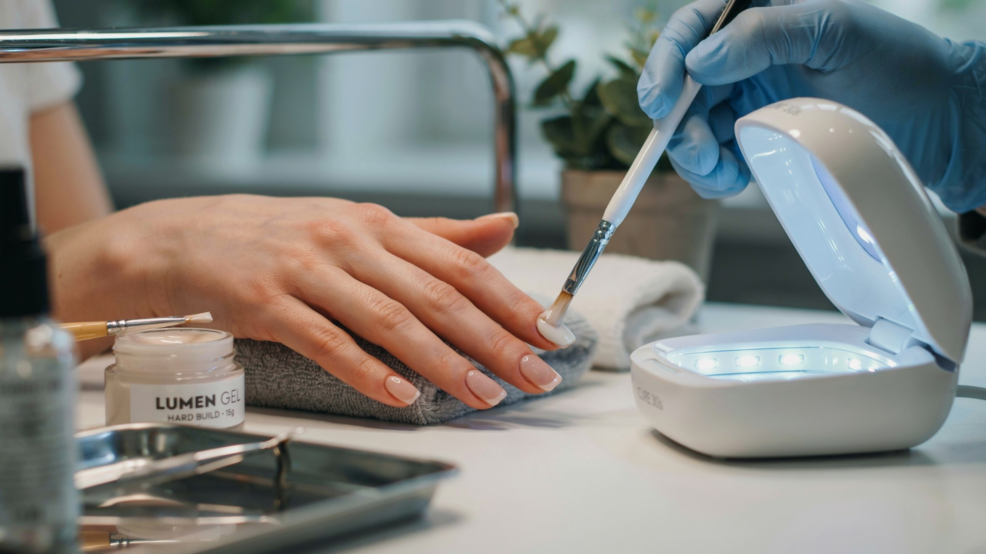 Hard gel being used to create a strong nail extension under UV lamp.