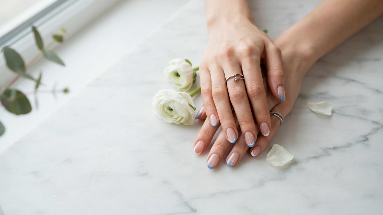 Classy almond-shaped nails featuring classic white and blue French tips with a glossy finish.