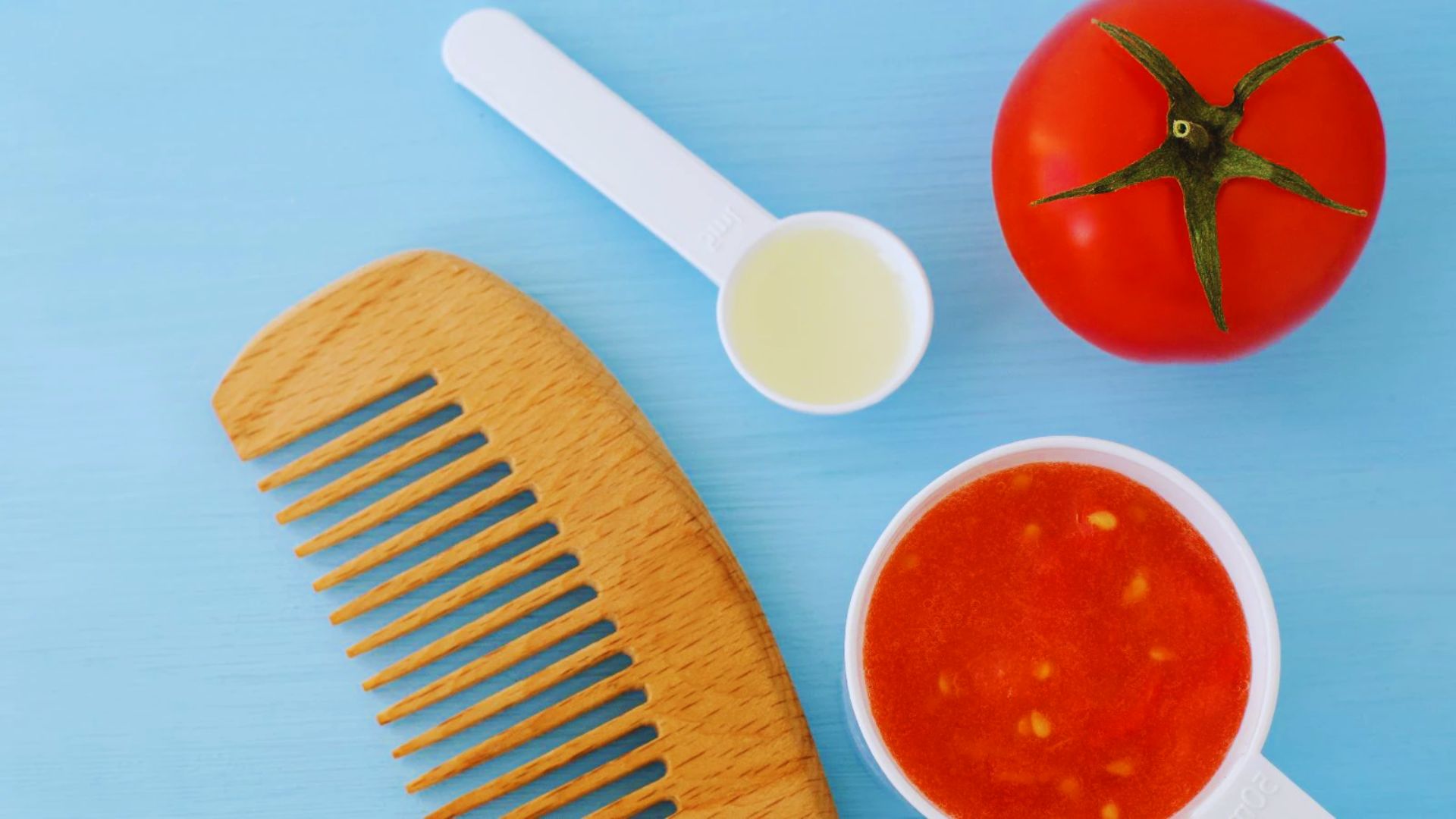 A wooden comb, baking soda, ketchup, and a tomato on a blue background.