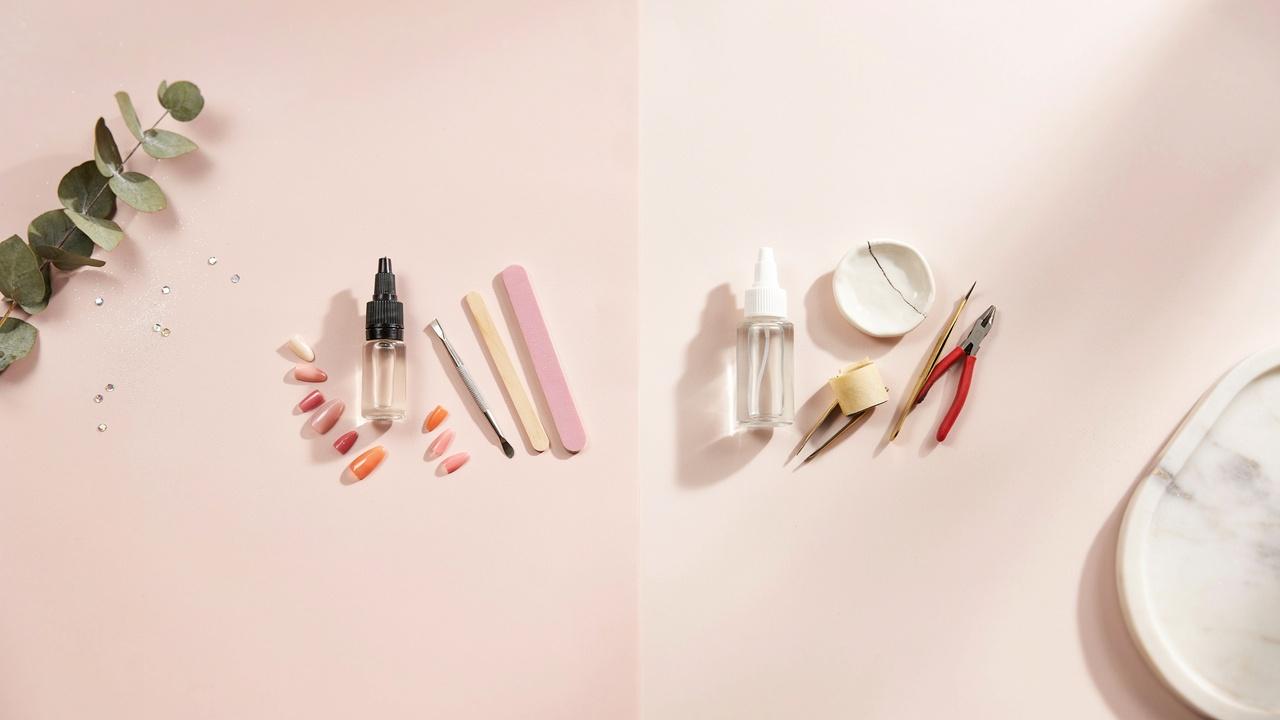 Two different adhesive bottles displayed with manicure and repair items to illustrate the comparison between nail glue and super glue.
