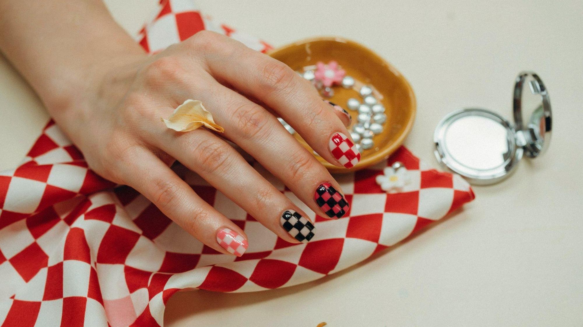 Short square checkerboard nails featuring colorful retro patterns creating bold playful manicure inspiration for everyone.