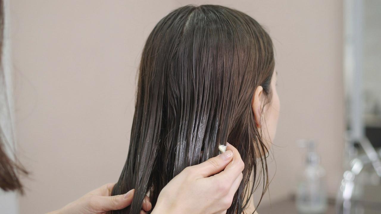 Conditioner being applied to hair ends only.