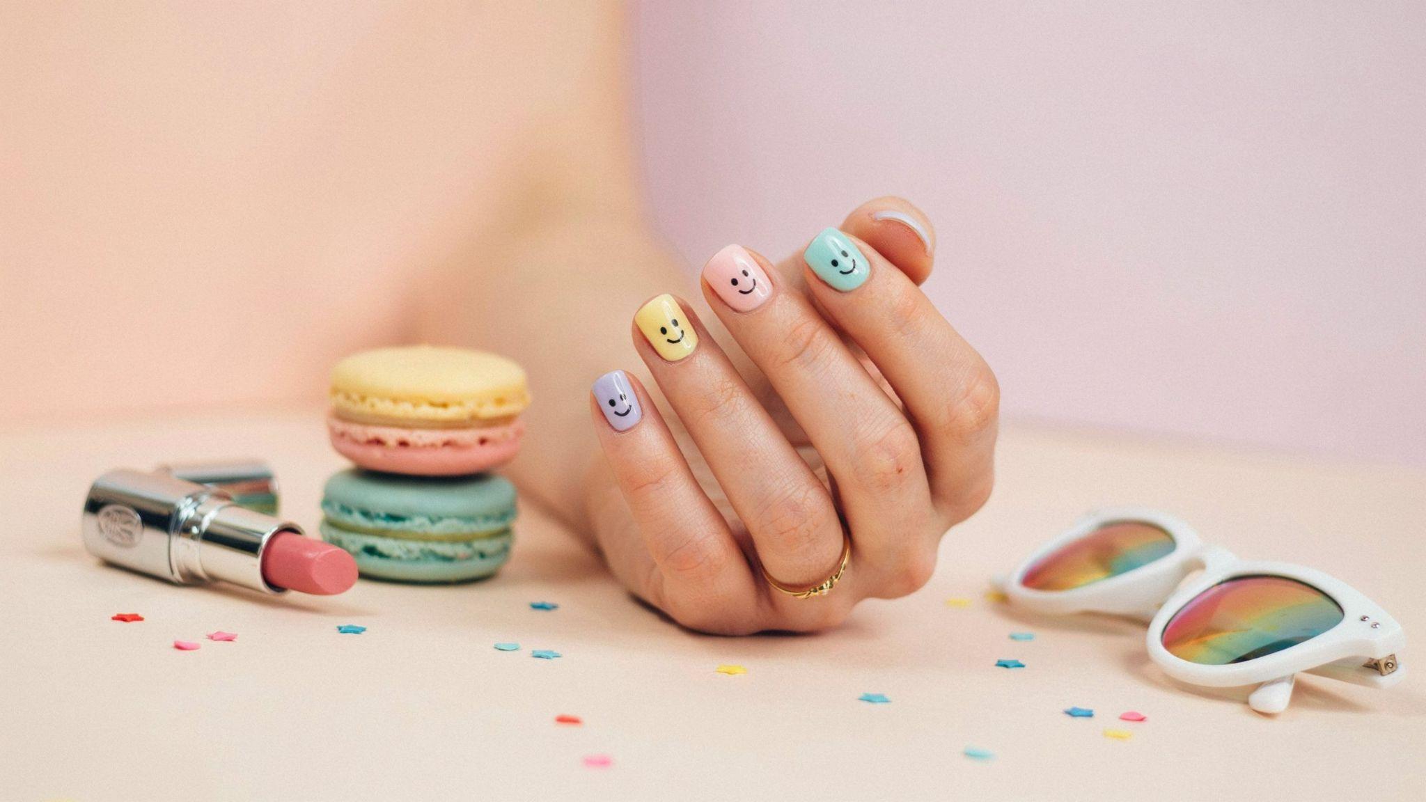 Short square nails featuring cheerful smiley face nail art with playful retro-inspired colorful manicure design.