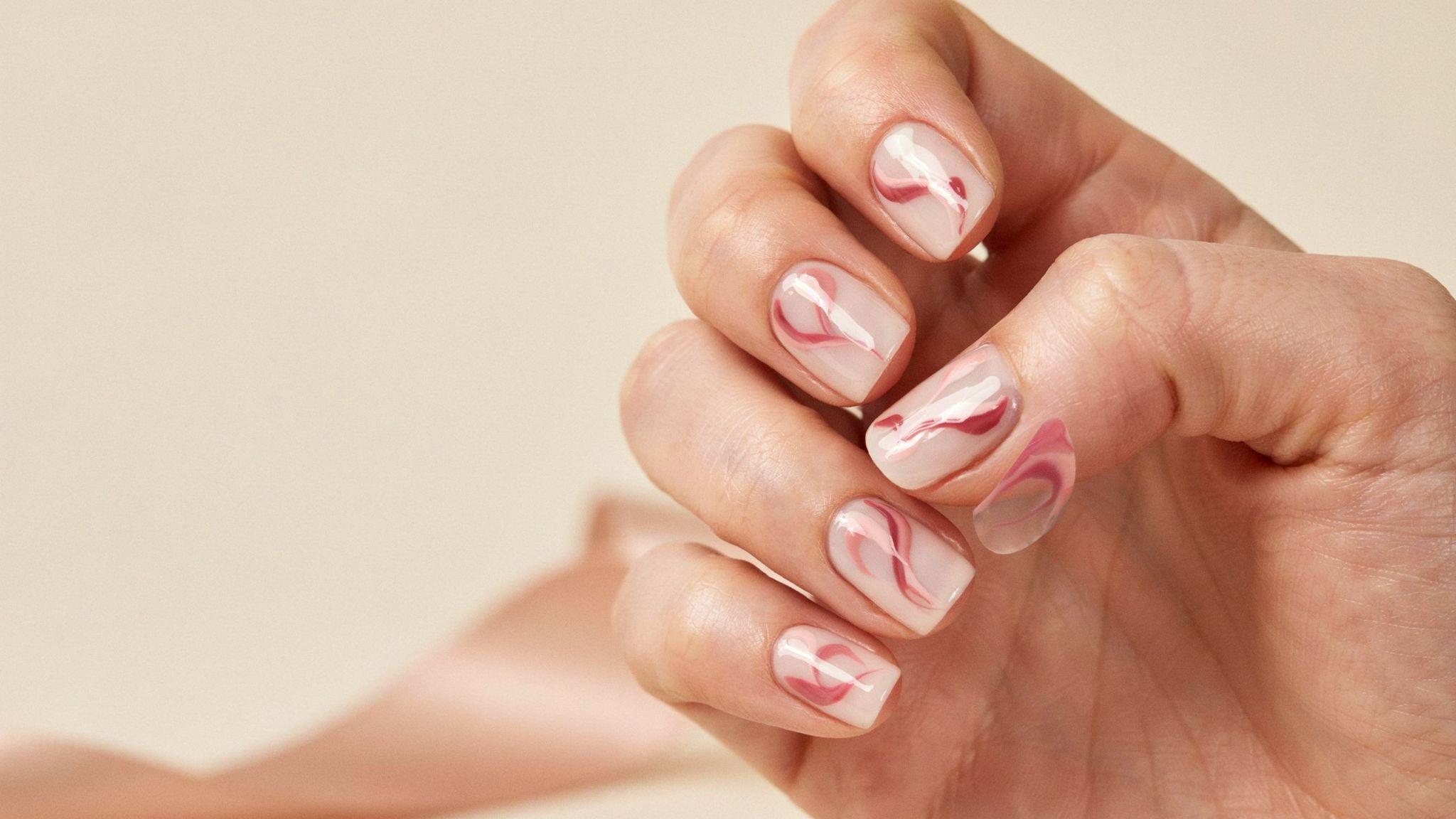 Pink swirl short square nails featuring abstract artistic lines over glossy nude and white manicure design.
