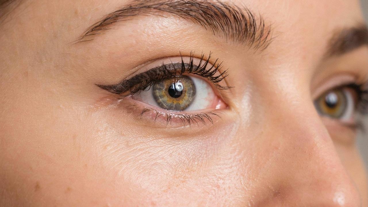 Winged permanent eyeliner lifting the outer corner of the eye.