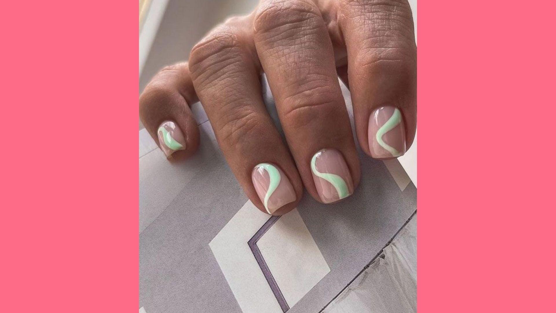 Short square nude nails with abstract mint green swirl designs outlined in white on magazine
